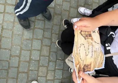 Zwei Personen halten eine alte Karte in der Hand, während sie auf dem Boden stehen.